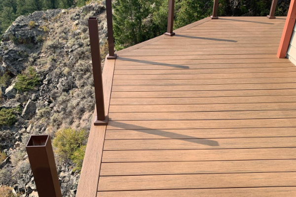 Warm brown deck attached to a mountain home