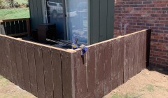 Walnut wood fence surrounding back door to end-unit condo