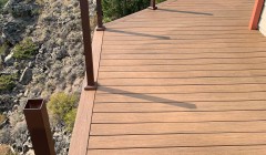 Large wooden deck and vertical wooden planks for future railing overlooking scenic forest