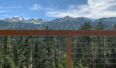 Scenic mountain view from wooden deck with cable railing