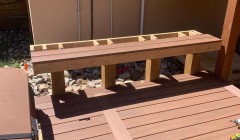 Framework for wooden bench beside covered hot tub and wood deck
