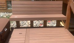 Wooden bench beside covered hot tub and wood deck