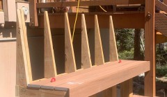 Partially finished wooden bench beside covered hot tub and wood deck