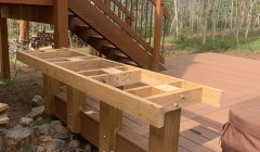 Framework for wooden bench beside covered hot tub and wood deck