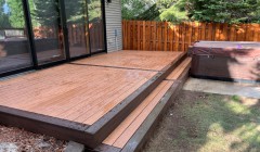 Two-toned wooden deck with full-width step from backyard