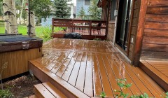Trex® deck and covered hot tub beside rustic wood cabin