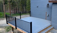 Small ground-level wooden deck painted blue to match siding of adjacent home