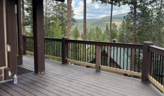 Cabin with walnut wood siding, matching wood deck and wooden railing