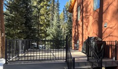 Composite wood deck with black metal railings outside orange house