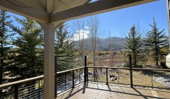 Light wood gazebo over composite wood deck with cable railings