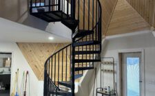 Black spiral indoor staircase with metal steps and railing