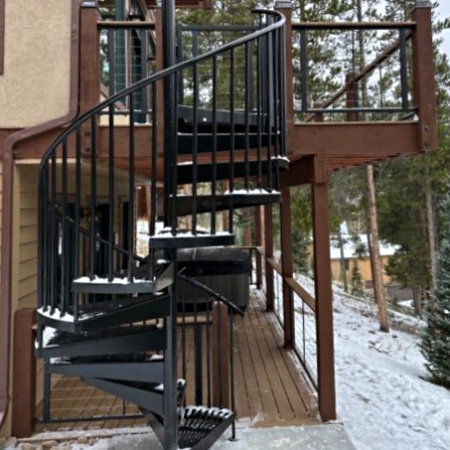 Spiral metal staircase leading to wooden outdoor deck