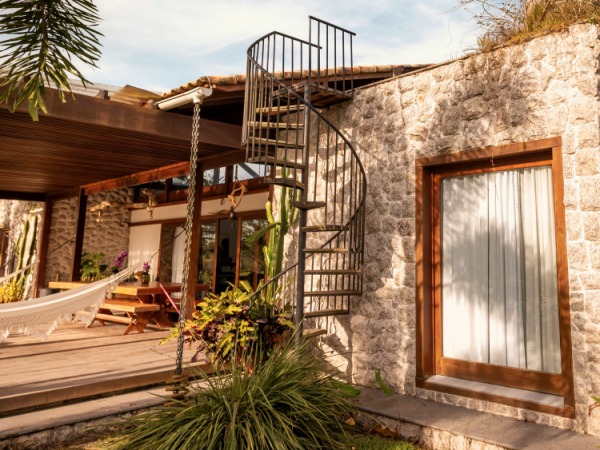 Black spiral staircase leading to rooftop patio of ranch-style brick home